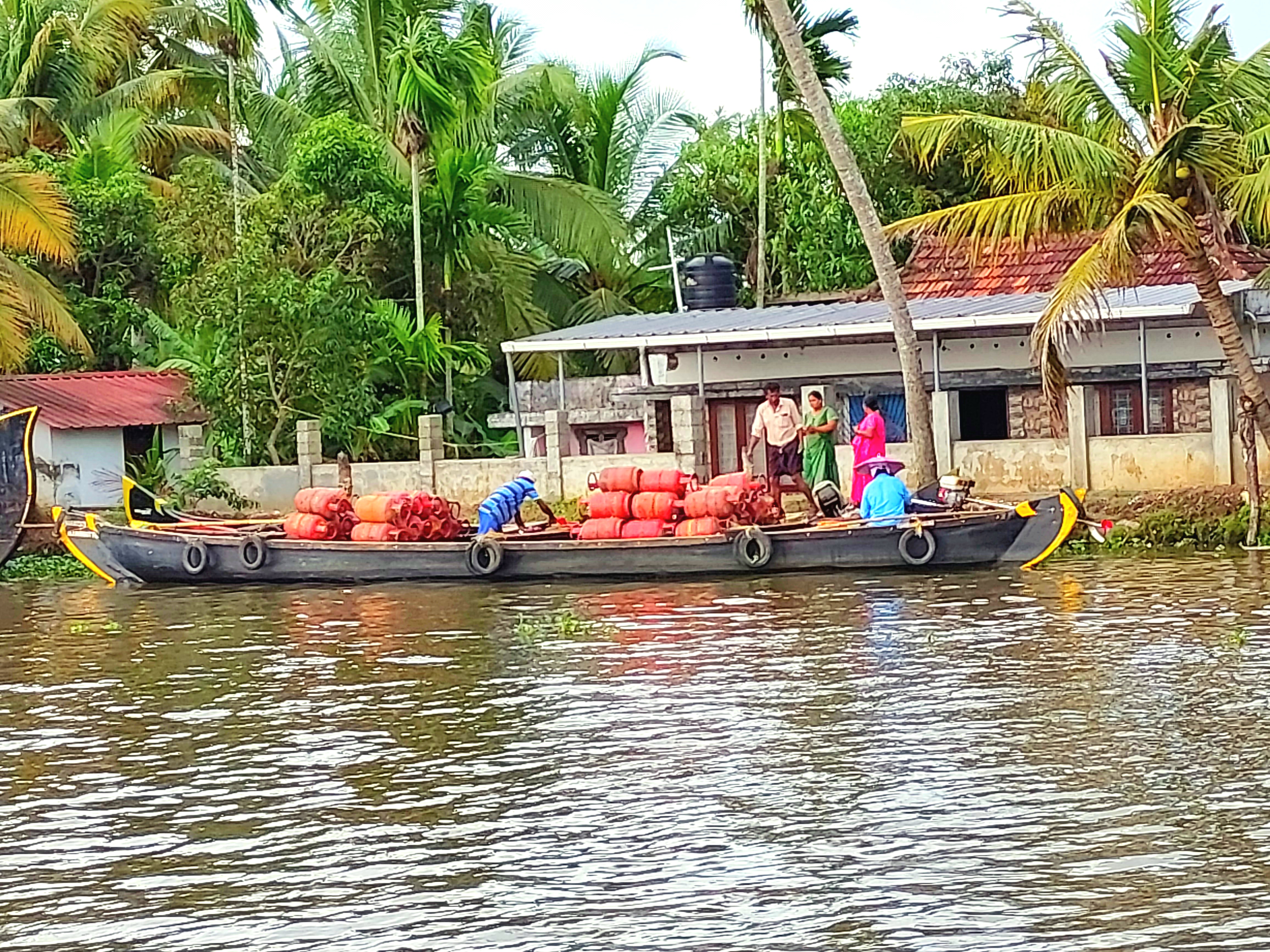 A worker supplying gas cylinders to homes in Allepey backwaters