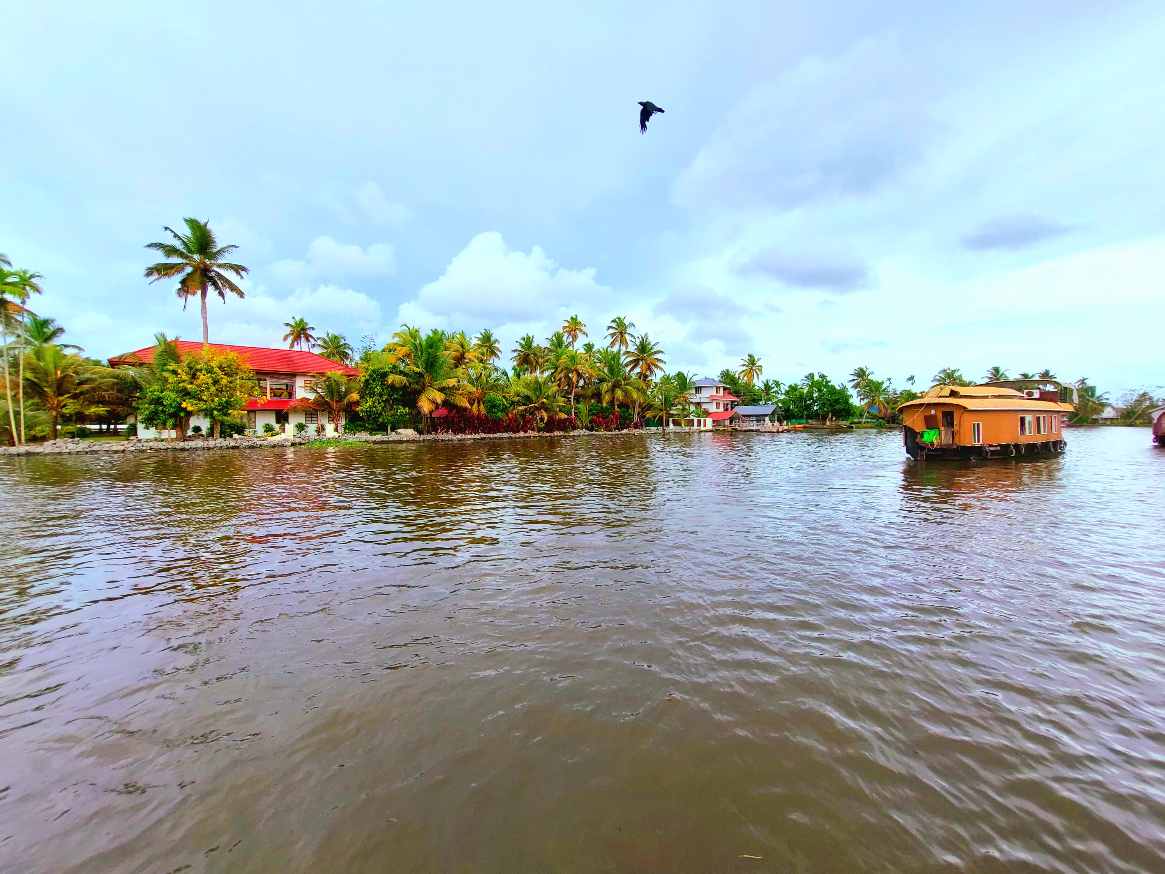 Traditional Kerala boathouse in Allepey backwaters sailing across a local home
Photo credit: Ameena Navab