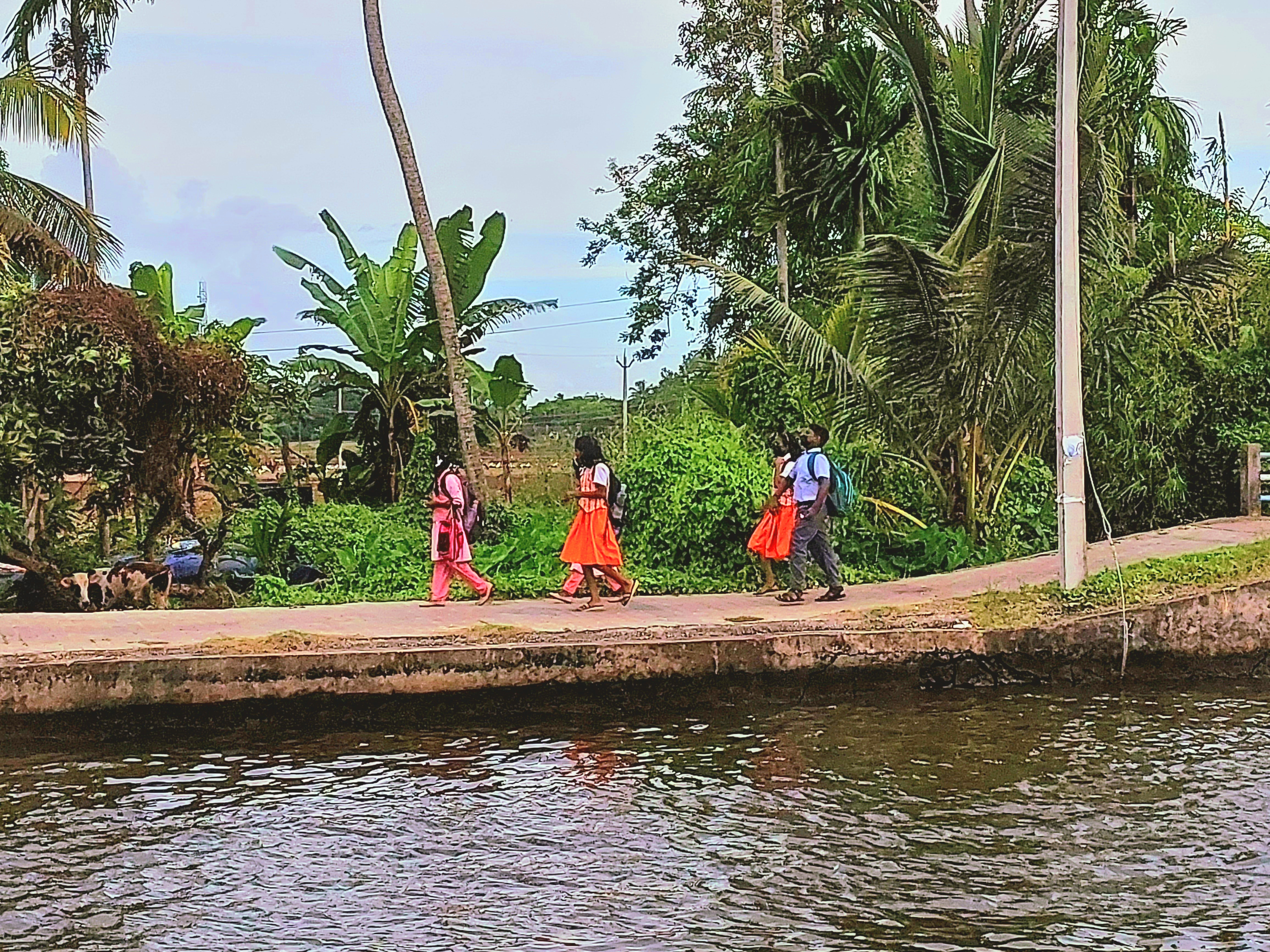 Children walking across the narrow walkways of the islands in Alappuzha backwaters Credit: AWO staff