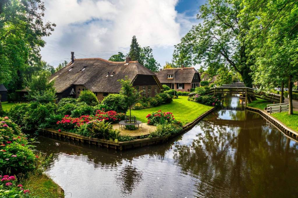 Traditional thatched roof houses amidst the interconnected canals of Giethoorn village Netherlands
